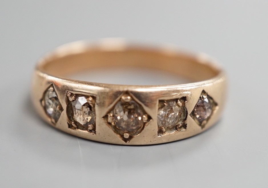 An early 20th century yellow metal and gypsy set graduated five stone diamond half hoop ring, size Q. gross weight 3.6 grams.